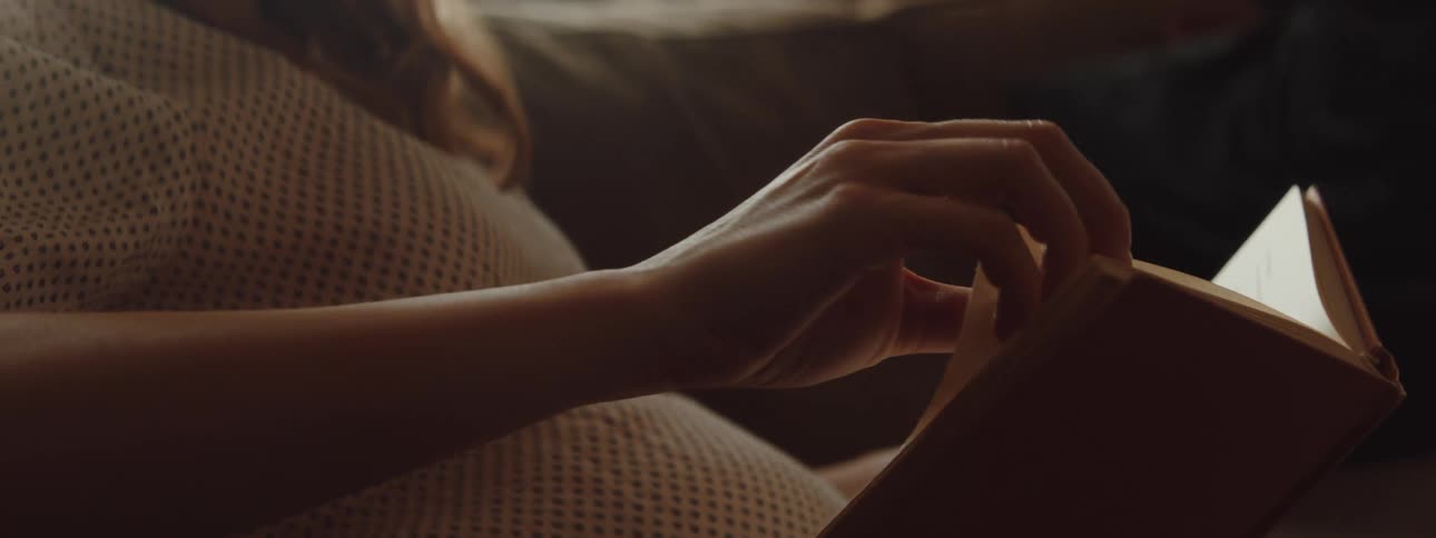 A woman is reading a book at home