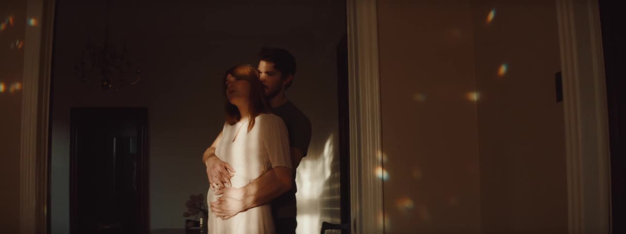 A couple hug in the dark hallway