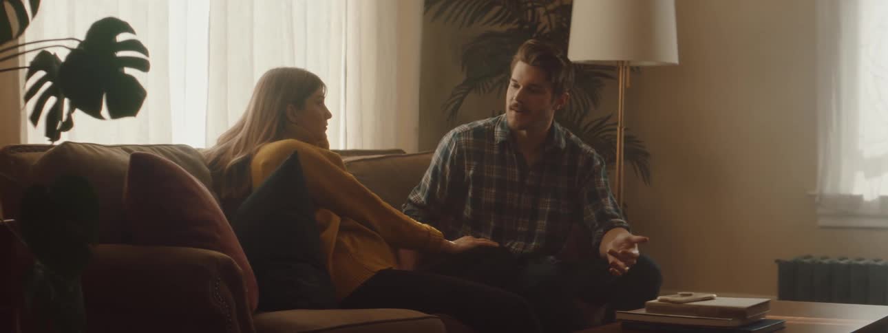 Man and woman are talking together while sitting on a couch