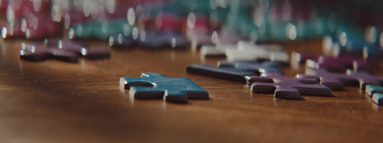 A woman picks up puzzle pieces