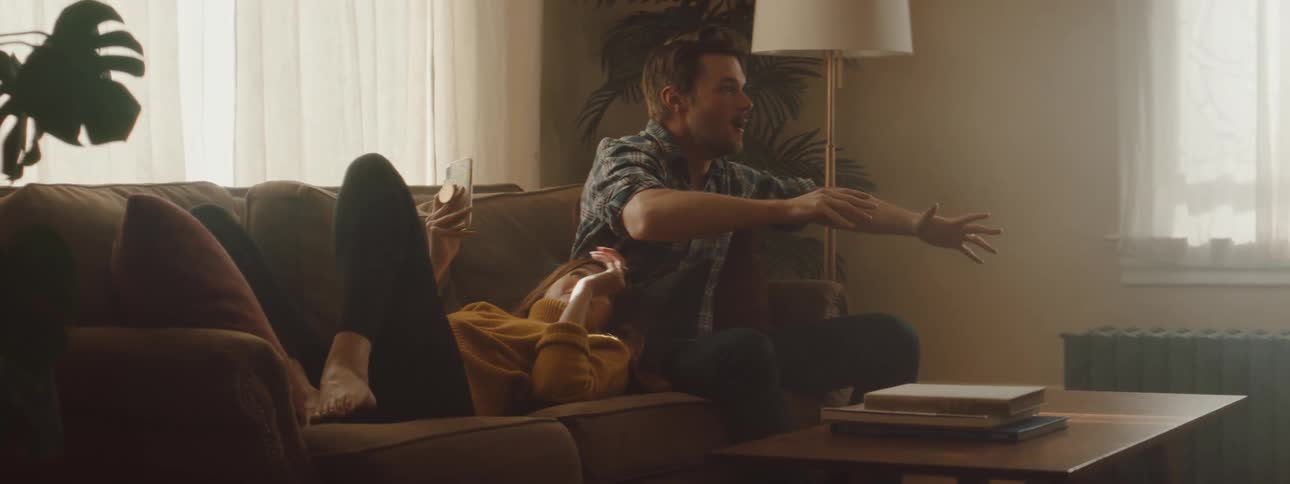 Husband and wife are sitting on the couch together in their living room