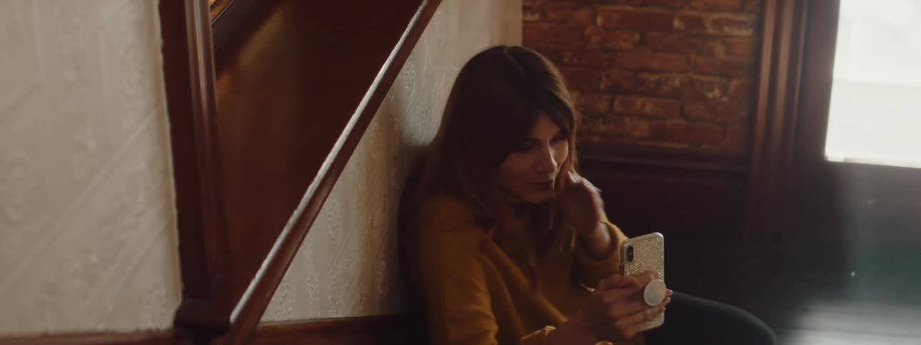 A woman talking on a smartphone in a room