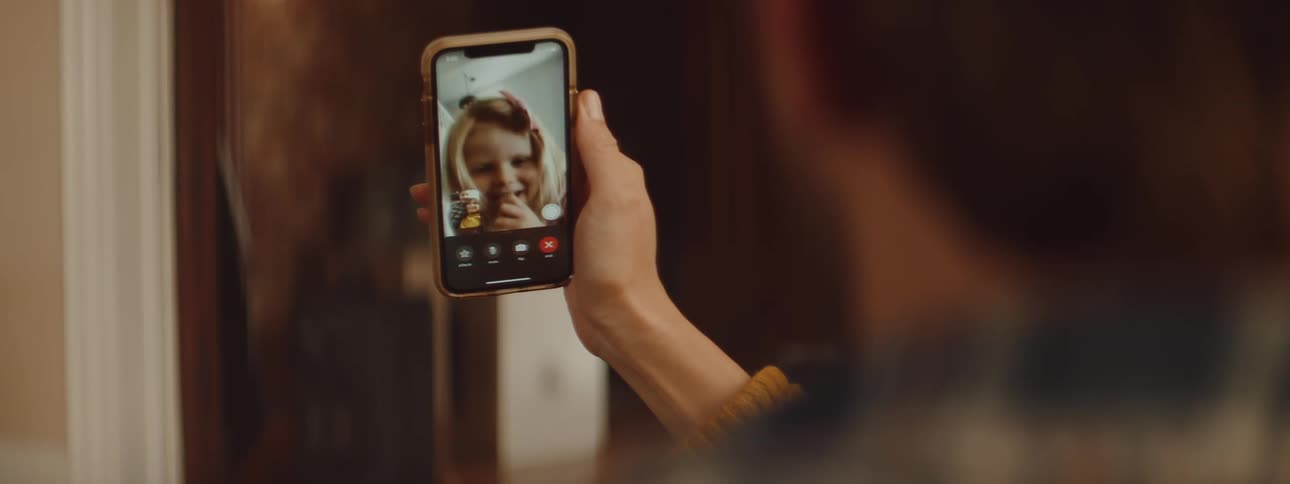 Man and woman make a video call with blonde little girl on the smartphone