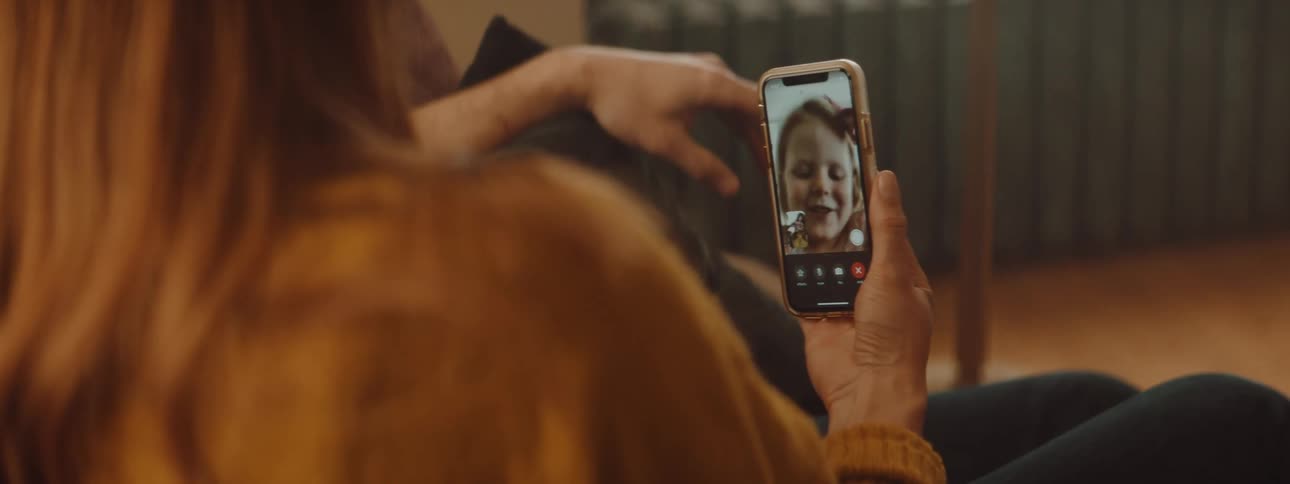 Woman talking to a girl on a video call through the phone