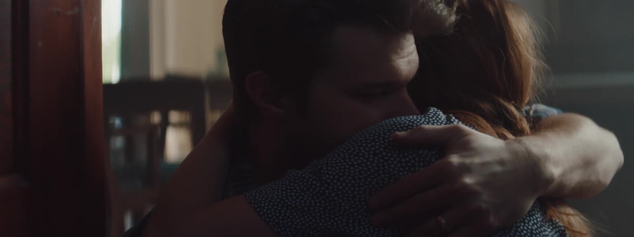 A couple hug on the floor of the home