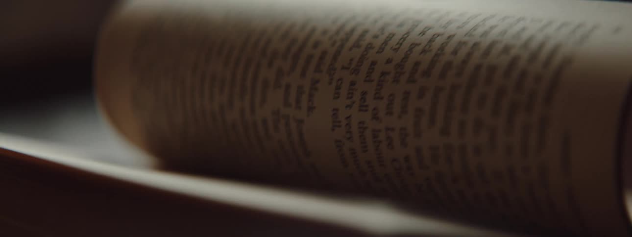 A person in a room flipping pages on a book