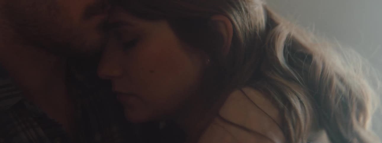 Man hugs a young sad woman in a room