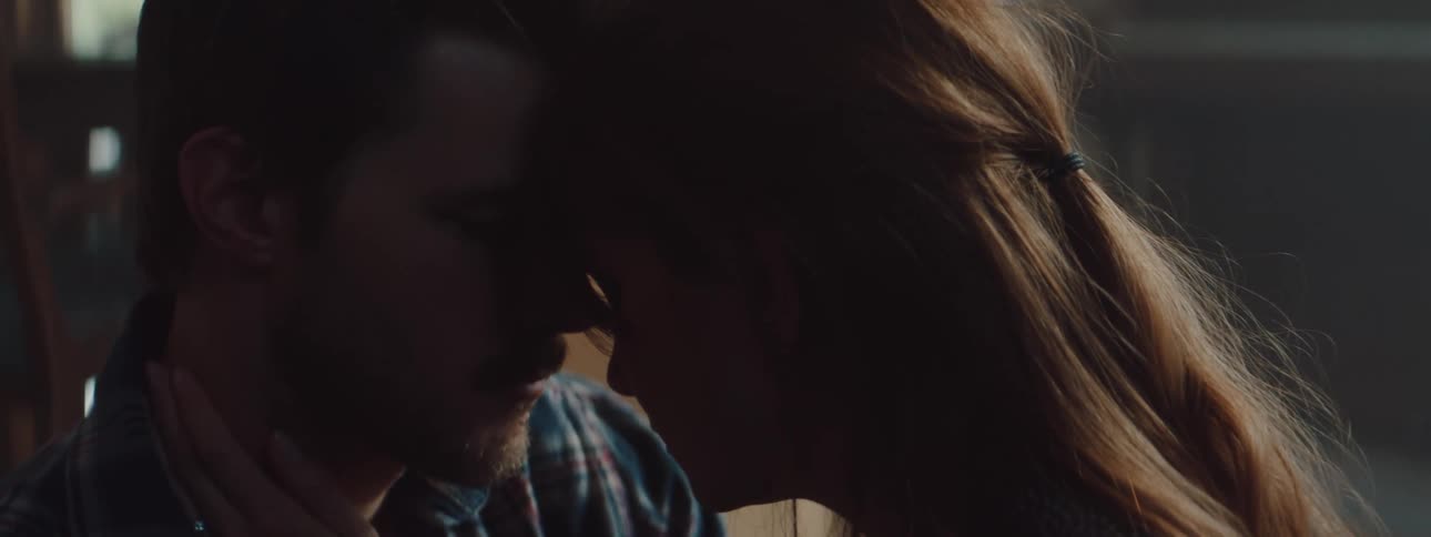 A white male and female couple standing close and caressing each other