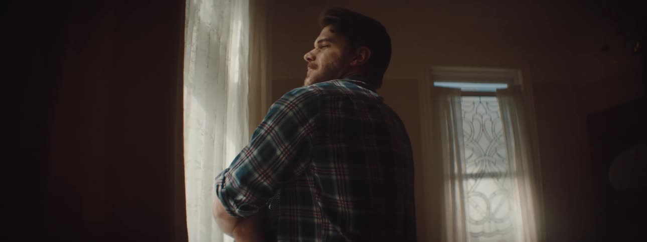 Young happy couple hugging next to a window in a room at home