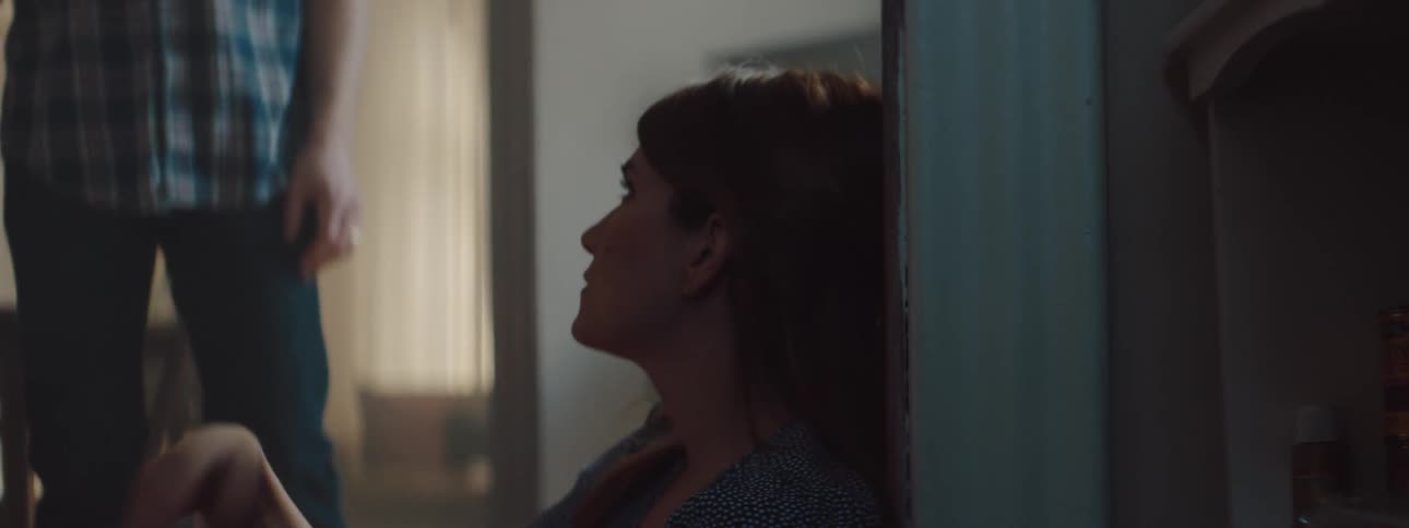 A man and woman are sitting on the ground inside of their house