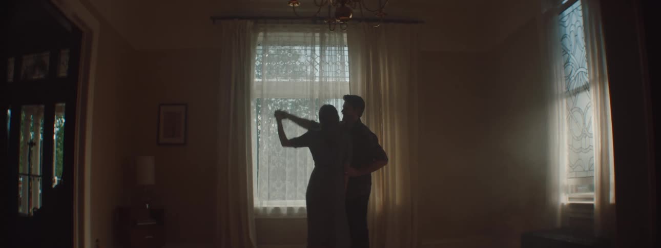 Husband and wife are dancing together in a room