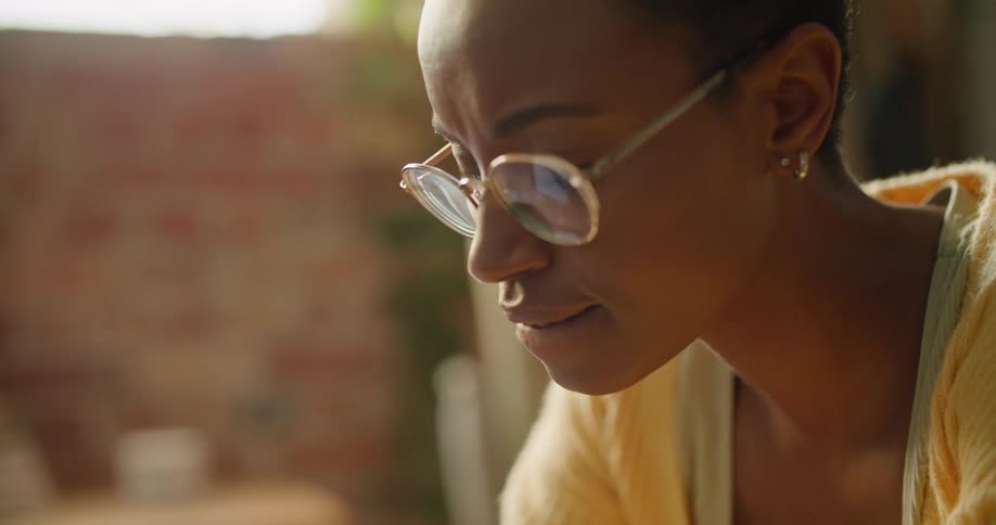 Woman wearing eyeglasses types on laptop