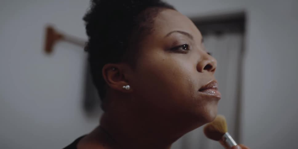 Woman applying makeup in the bathroom