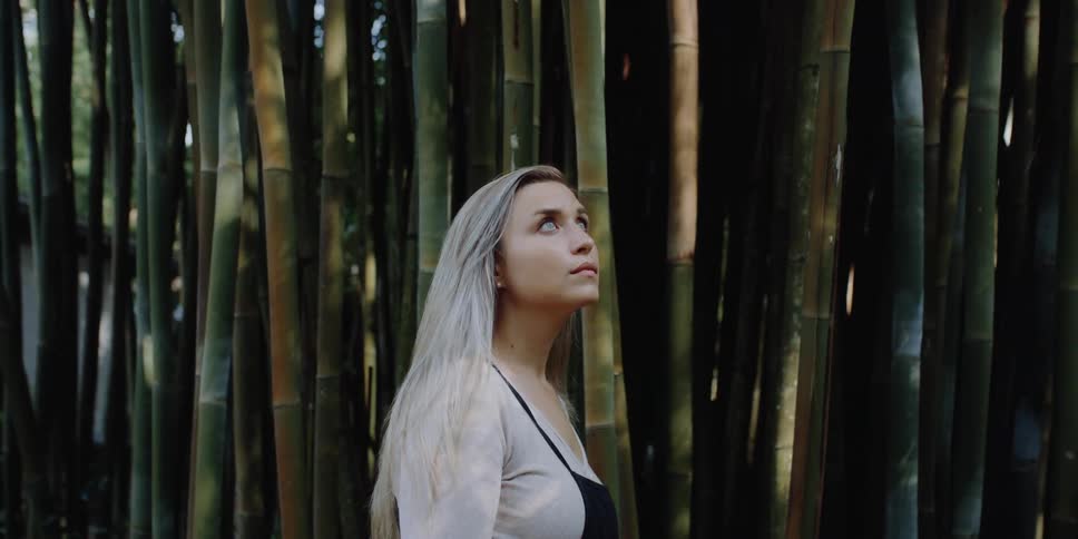 A female caucasian standing outside near a lot of bamboo plants