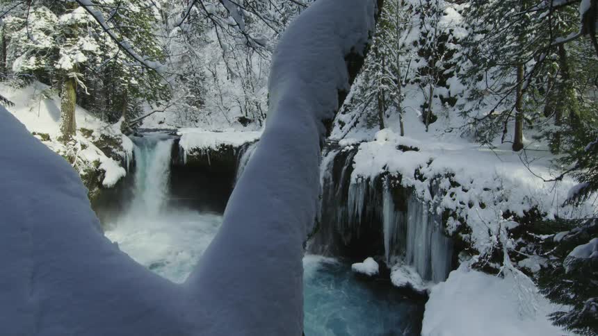 Static shot showing a stunning waterfall in the middle of the winter after a massive blizzard dumped feet of snow on the beautiful river valley just before Valentines Day