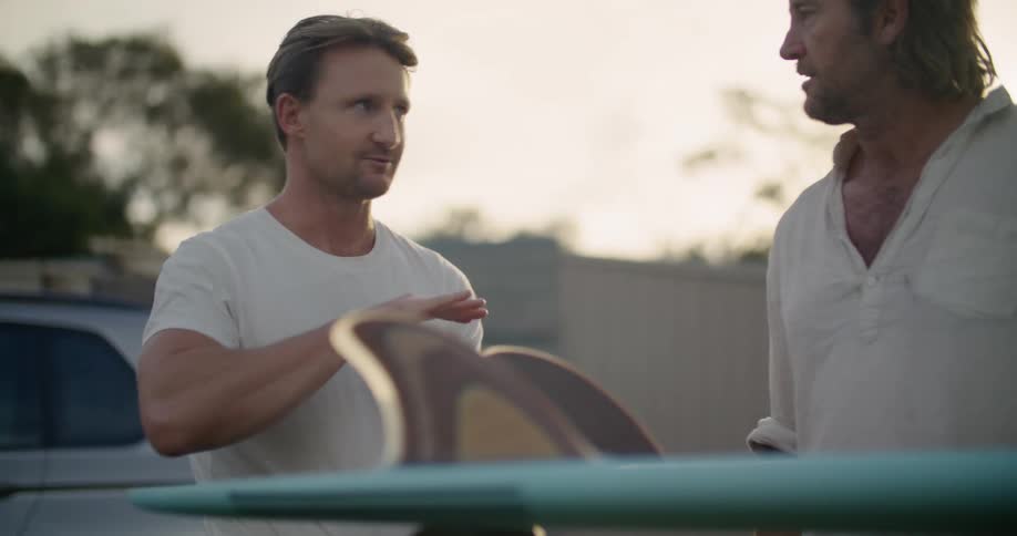 Two men are talking outdoors at dusk in spring