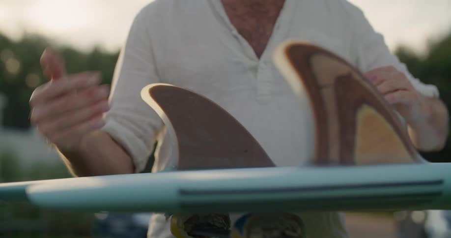 A man is standing outdoors at dusk and talking