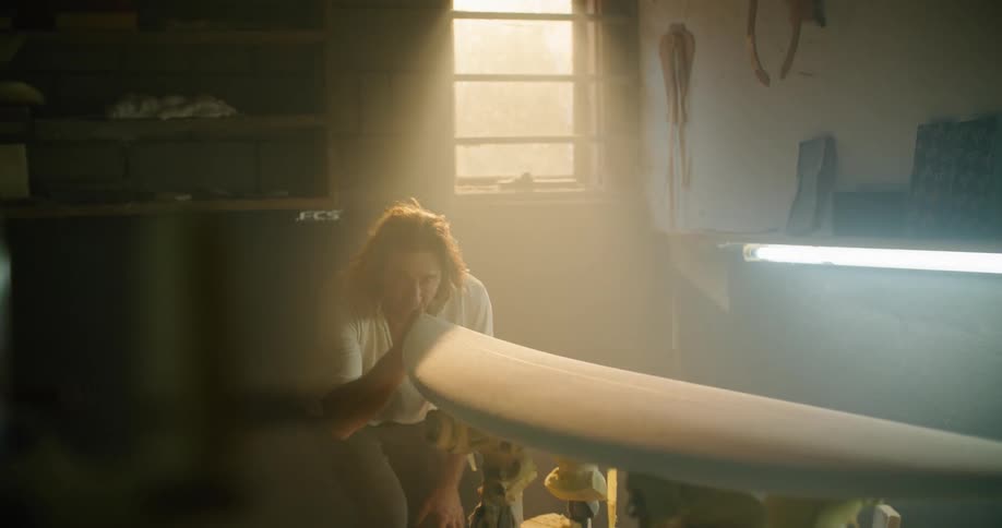 A man is looking at a piece of furniture indoors at dusk