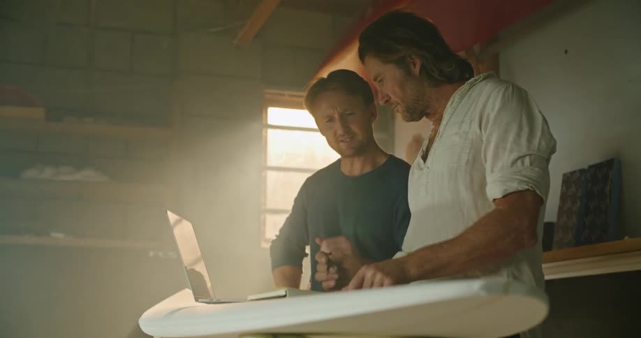 Two men are talking to eachother inside of a garage