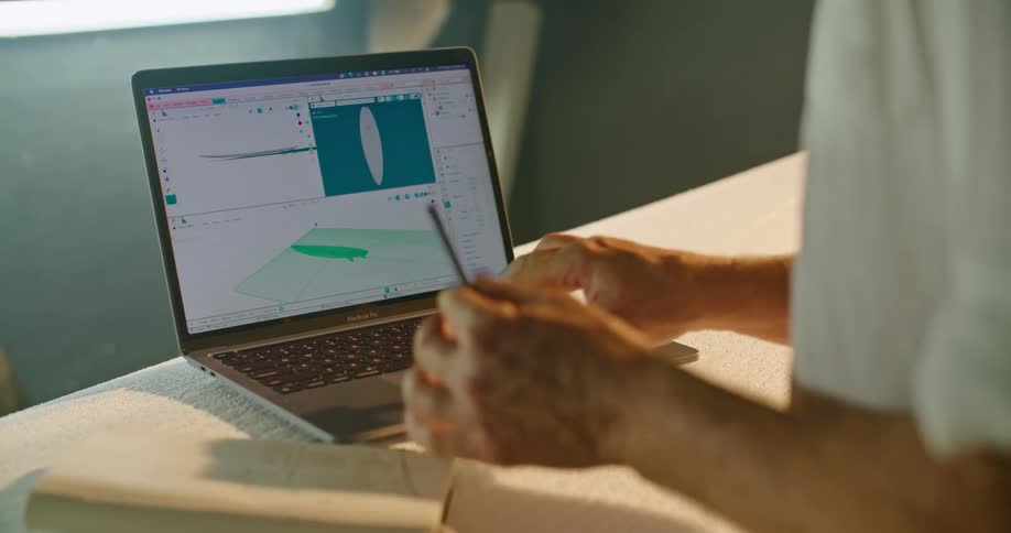 A surfboard designer using a 3D program to test his design