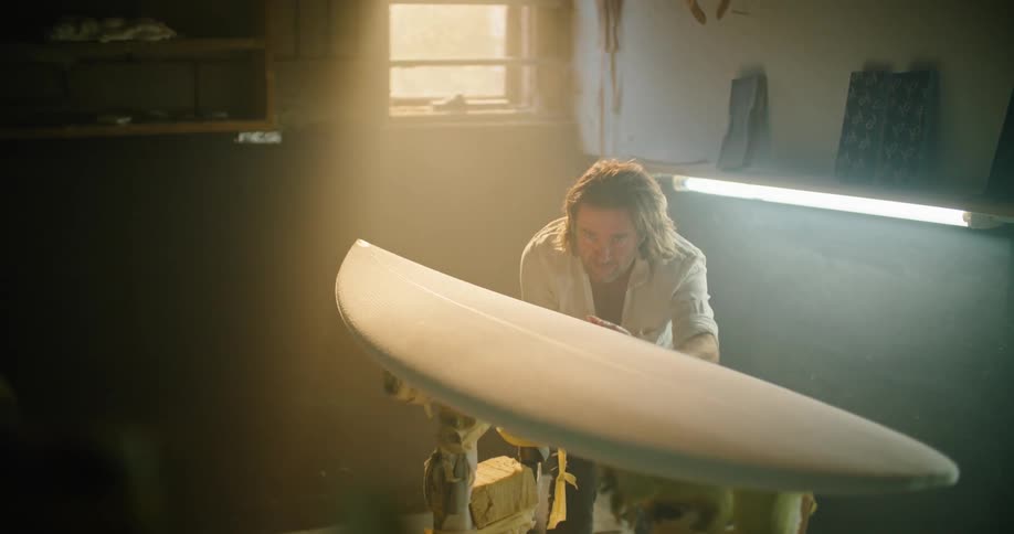 A man is cleaning furniture indoors at dusk