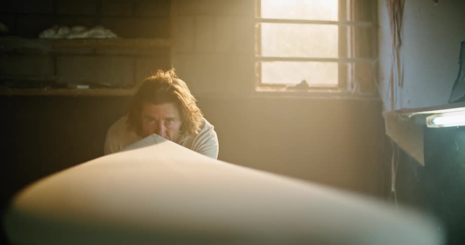 A man checks the design of a surfboard