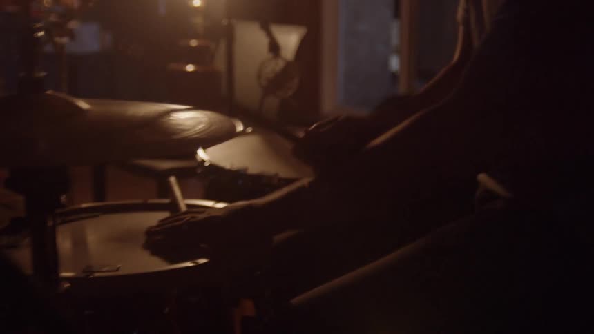 A male drummer with a t shirt plays the drum