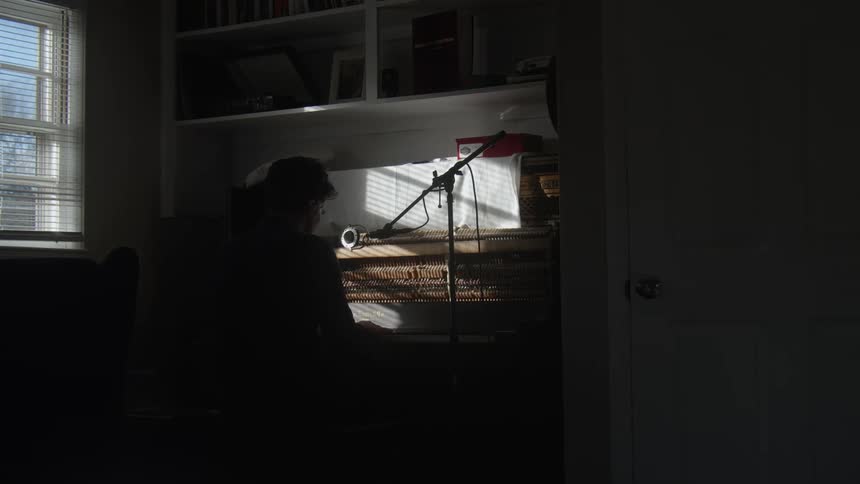 A person playing a pianola inside a dimly lit room