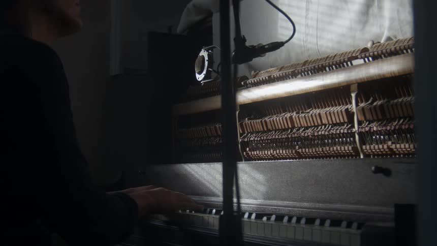 A person is sitting down and playing the piano