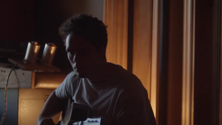 Man playing guitar in a dimly lit room