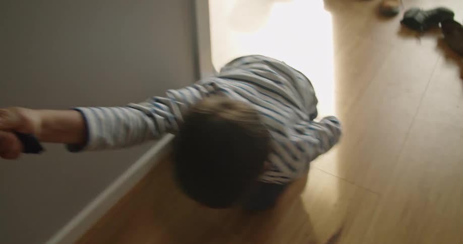 Boy tugging the clothes of his father playing on the floor at home
