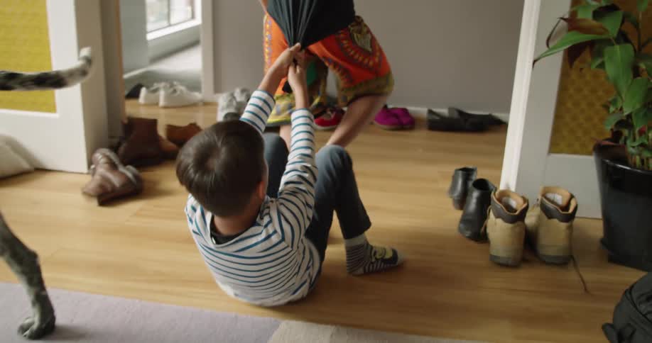 Two siblings playing in the living room at home near their pet dalmatian dog