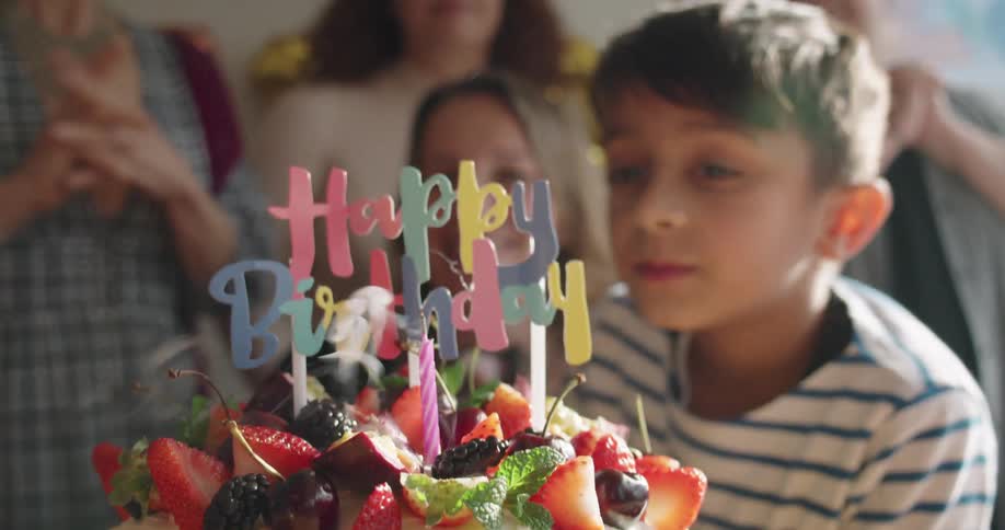 A child blowing out candles on a cake