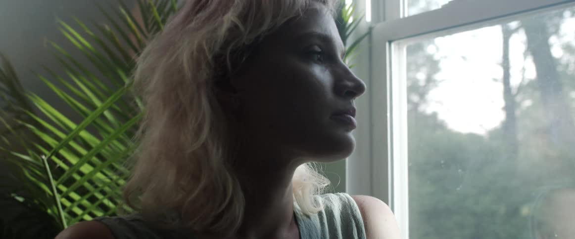 Side view of blonde woman looking out the window