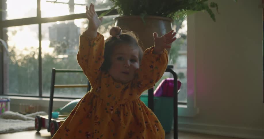 A child raises her arms up and falls