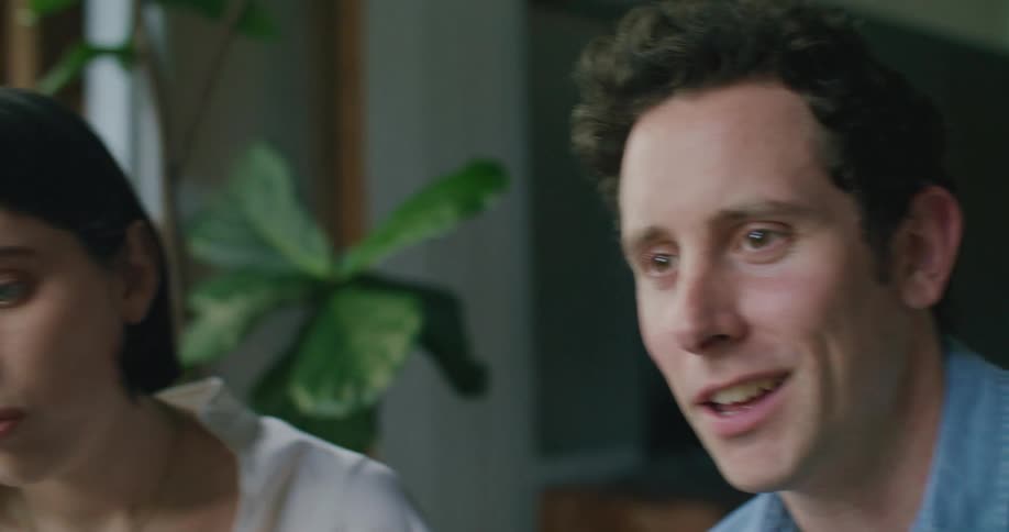 A man and woman are talking together in a room