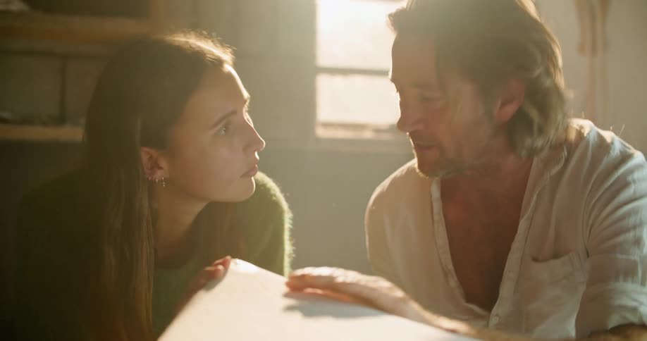 A man and woman looking at a surfboard
