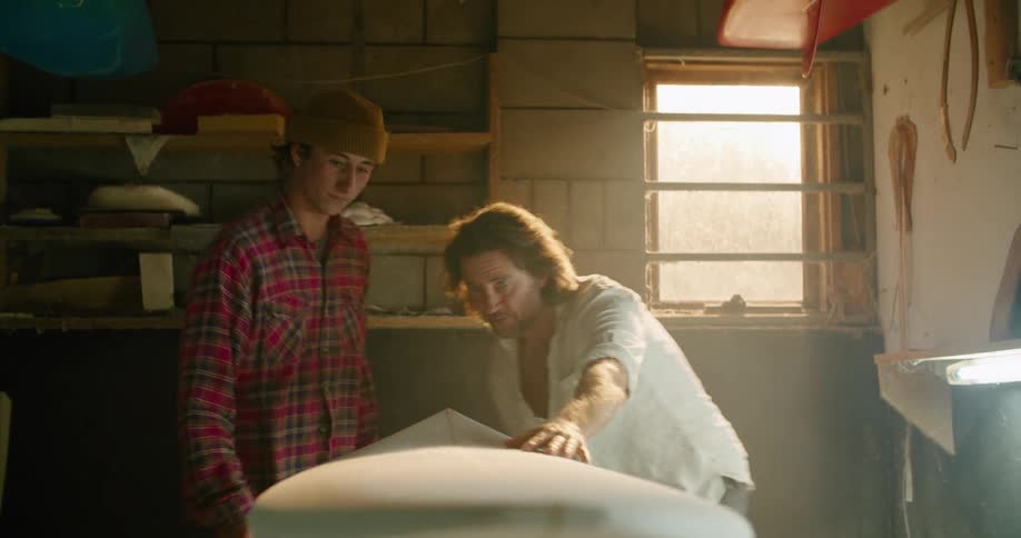 A man and his son admired a newly carved surfboard in their garage