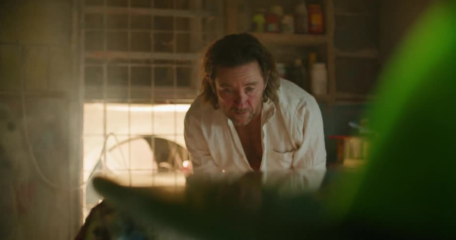 A man is standing indoors and cleaning furniture