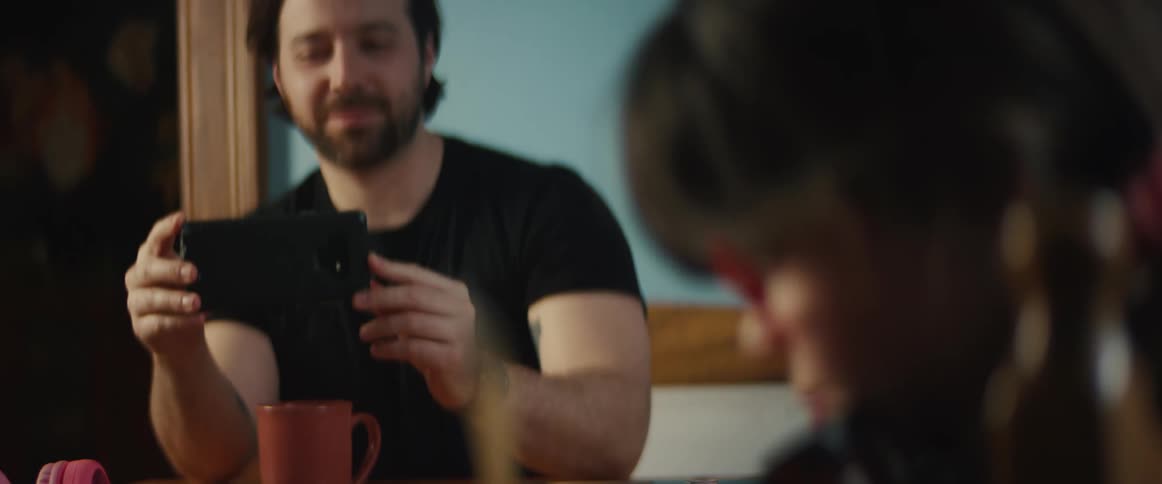 Man uses his phone to film a girl playnig the violin