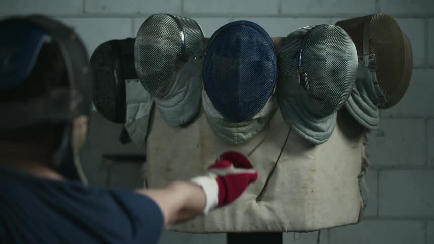 A person is practicing fencing on a training pad