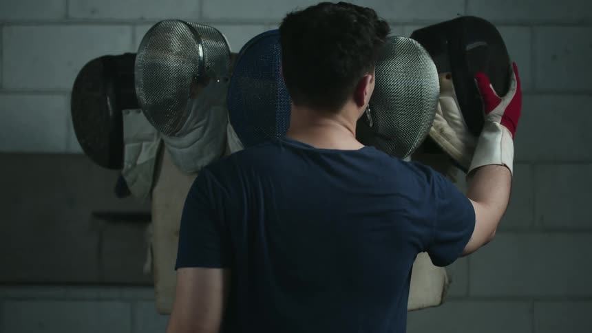 A person taking off a helmet and hanging it up