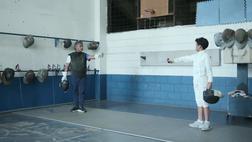 Student and fencing instructor salute each other standing near basketball hoop
