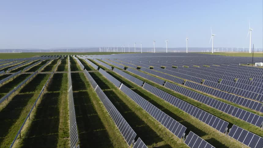 Solar panels and wind turbines generate clean power together at a renewable energy installation