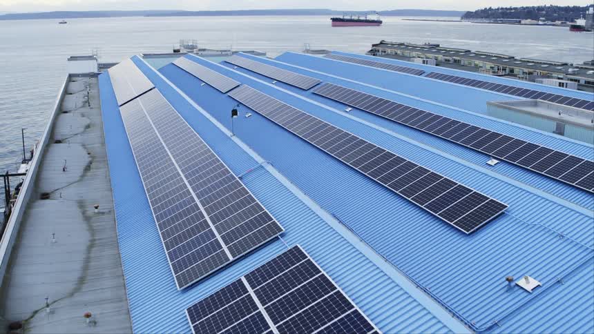 Rooftop solar panels provide electricity to a commercial building along a pier