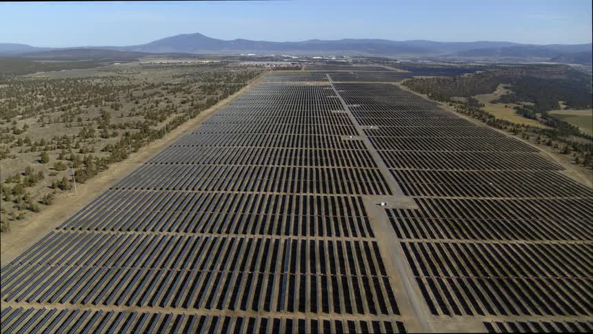 Subtle orbit over long rows of solar panels at a large solar power facility