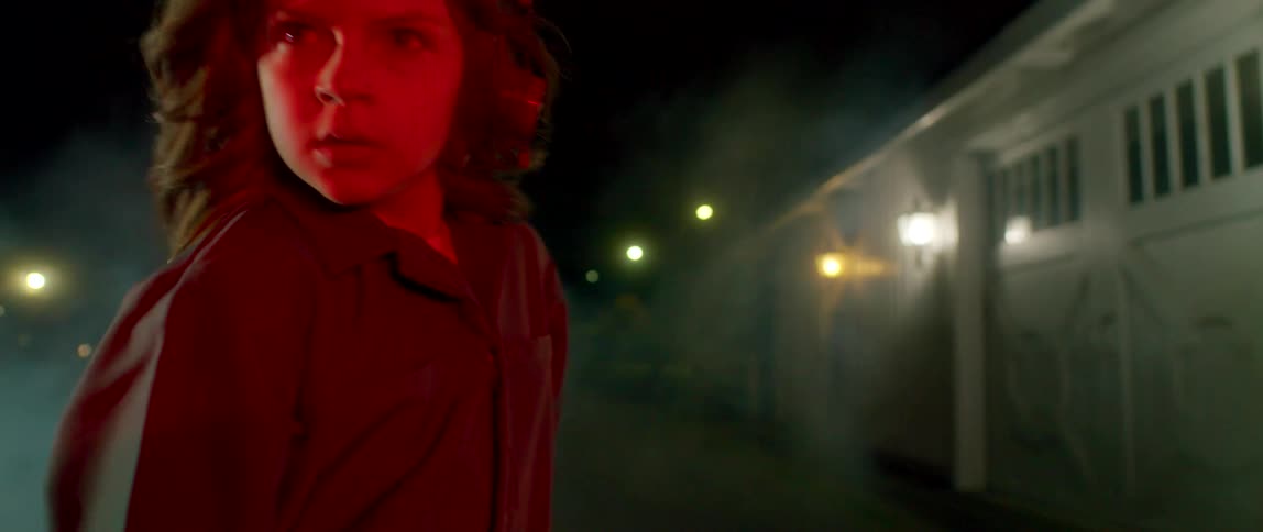 A girl is dancing outside at night