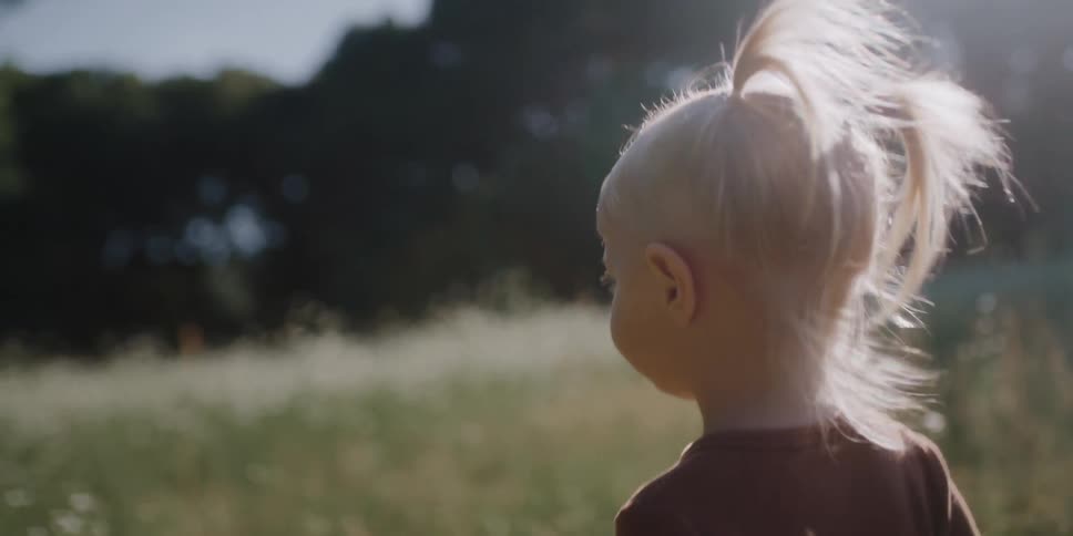 A child is walking through the tall grass