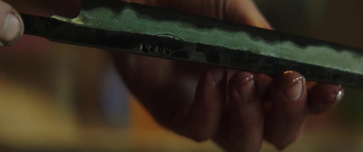 A person holding a knife blade