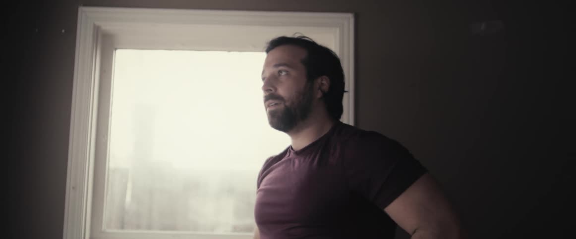 A male caucasian sweating and lifting a kettlebell in a room